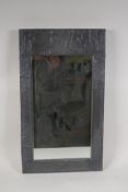 An Arts and Crafts design embossed pewter framed mirror
