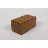 A Chinese soapstone seal box with carved character decoration to the cover, opening to reveal a