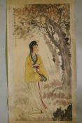 A Chinese watercolour scroll depicting a woman standing under a tree, signed with a seal, 26" x 53"