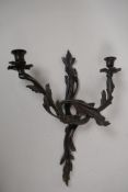 A bronze two branch wall mounted candelabra (sconce) cast as entwined leaves, 16" long