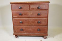 A Victorian pine chest with original grain painted decoration and bun handles, raised on turned