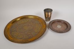 A Cairo ware brass tray with Islamic decoration, 13½" diameter, together with a smaller tray and