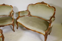 A C19th walnut two seater settee with carved decoration and pierced back, raised on cabriole
