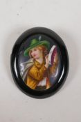 An antique European hand painted porcelain brooch depicting a tambourine player, 2" x 2½"