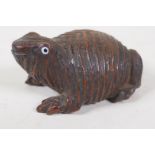 A C19th carved wood snuff box in the form of a frog with glass eyes, 3" long