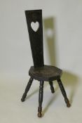 A C19th ebonised wood stool with carved seat and back