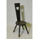 A C19th ebonised wood stool with carved seat and back