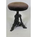 An Aesthetic Movement ebonised revolving piano stool, 21" high