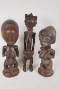 Three African carved hardwood fertility figures, largest 17½" high