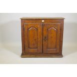 A C19th French fruitwood cupboard, two doors with shaped fielded panels, raised on a plinth base,