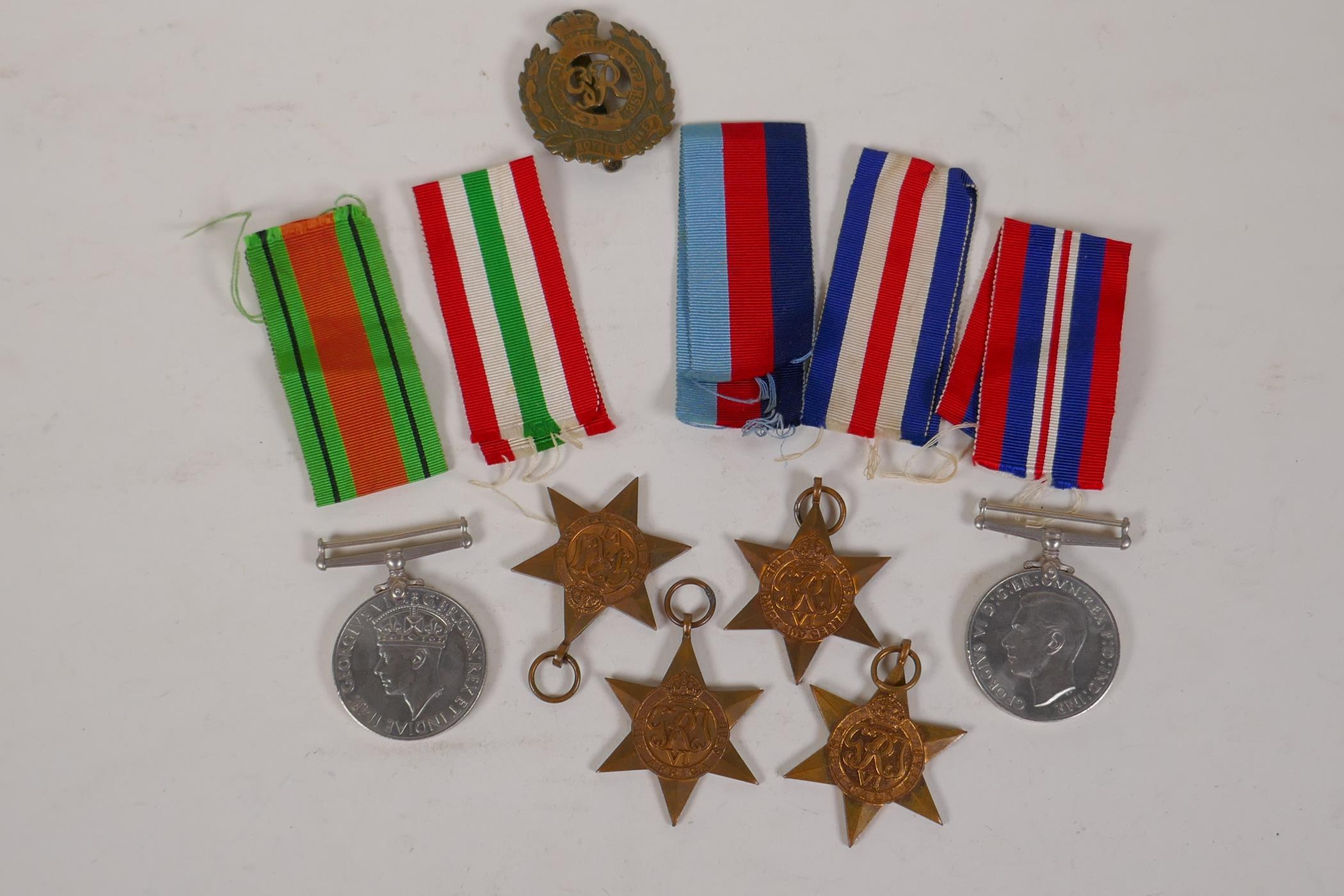 A collection of WWII medals and ribbons, and a Royal Engineers cap badge