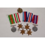 A collection of WWII medals and ribbons, and a Royal Engineers cap badge