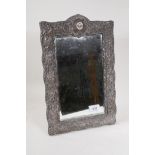 An Art Nouveau hallmarked silver easel mirror with scrolling repousse decoration, Birmingham 1900,