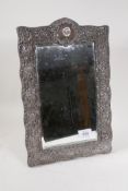An Art Nouveau hallmarked silver easel mirror with scrolling repousse decoration, Birmingham 1900,