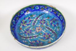 A Palestine pottery shallow bowl painted with flowers, 10" diameter