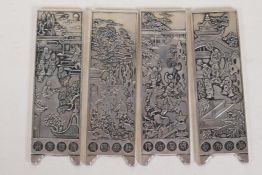A set of four Chinese white metal scroll weights in the form of screen panels, decorated with garden