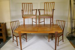 A Macintosh T3 extending dining table with fold out extra leaf on turned supports, 29" x 62" x 36"