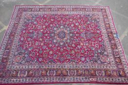 A vintage rich red ground Persian Mashad carpet, signed, small matched repair, 116"  x 148"