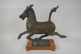 A Chinese bronze figure of a running horse, on a hardwood stand, 12" high