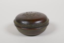 A Japanese bronze ink box with bamboo and character decoration to the cover, 3" diameter