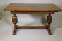 A Jacobean style oak draw leaf table with carved frieze on refectory carved bulbous end supports and