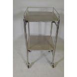 A two tier stainless steel medical instrument trolley on castors, 37" x 19" x 18"