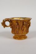 A Chinese gilt metal libation cup of octagonal form, the eight sides with raised figural decoration,