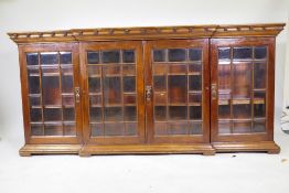 A Victorian mahogany library breakfront bookcase, with a decorative frieze over four doors with