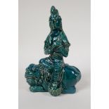 An emerald glazed porcelain Quanyin seated on a kylin, 8½"
