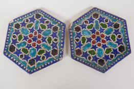 A pair of Persian hexagonal stoneware tiles painted with geometric patterns, 7" wide