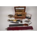 A vintage vanity box containing cut throat razors, collar studs, retracting pencils, smoking