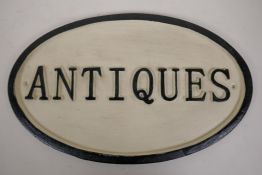 An oval cast iron 'Antiques' sign 13½" x 8½"