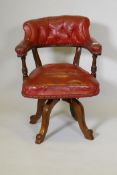A Victorian mahogany swivel desk chair with buttoned leather upholstery