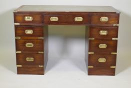 A mahogany veneered campaign pedestal desk with nine drawers and a leather inset top, 48" x 24", 30"