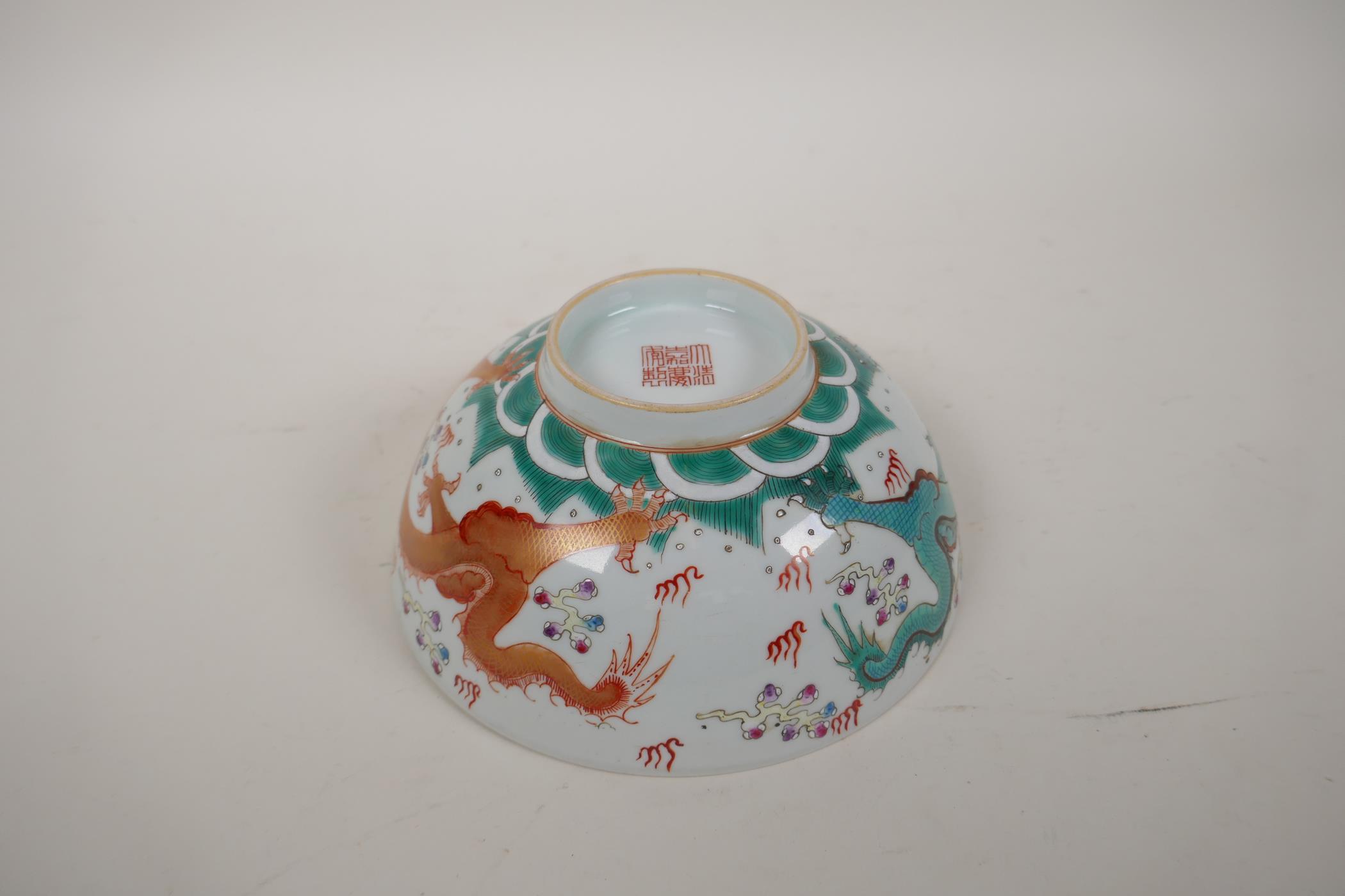 A polychrome porcelain bowl decorated with an iron red and green dragon chasing the flaming pearl, - Image 12 of 14