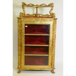A C19th Italian giltwood corner cabinet, the top with an open shelf supported by dolphins, the