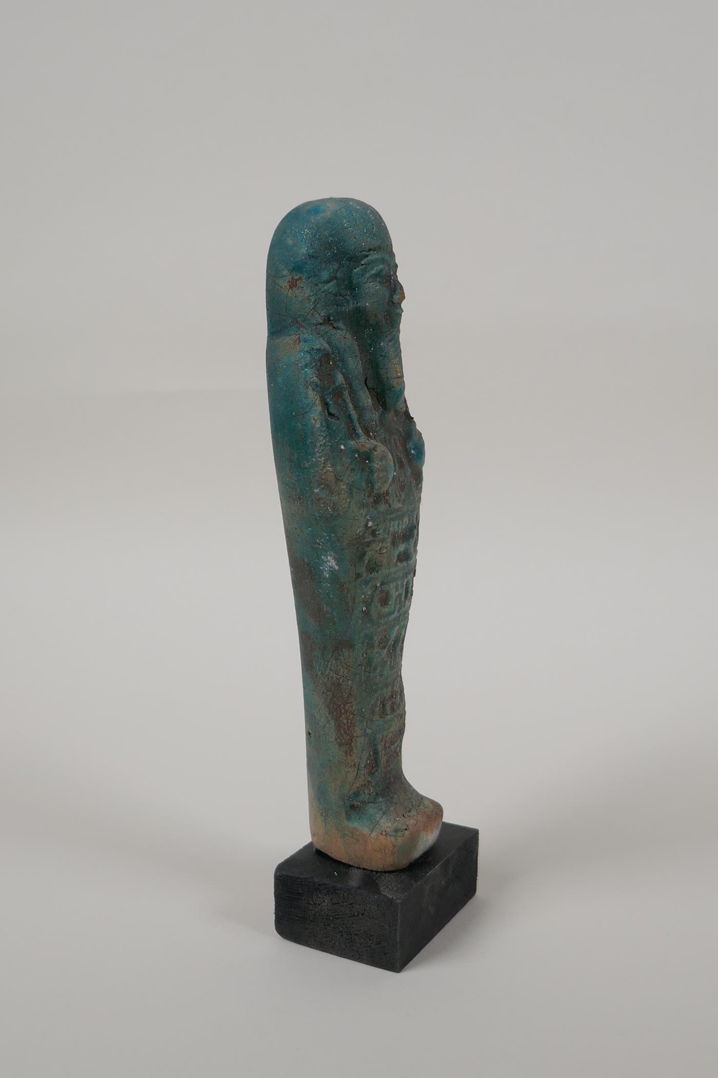 An Egyptian turquoise glazed faience shabti, mounted on a display base, 7" high - Image 3 of 5