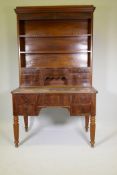 A C19th continental mahogany desk, the upper section with open shelves and seven drawers, the base