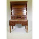 A C19th continental mahogany desk, the upper section with open shelves and seven drawers, the base