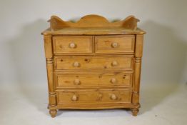 A stripped pine chest with three quarter gallery serpentine shaped top, two over three drawers