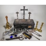 A plated deed box containing a brass hand bell, silver plated alter set, brass candlesticks,