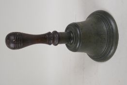 A heavy brass hand bell with turned wood handle, 12" long