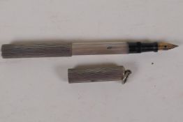 An unmarked silver chatelain ink pen in a rib machined case, 4" long