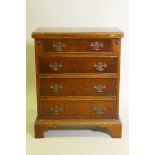 A yew wood veneered bachelor's chest, with fold out top over four drawers, raised on bracket