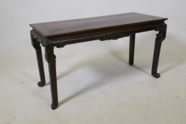 An antique Chinese hardwood low/scholar's table, with carved frieze and shaped supports, 30" x 12" x