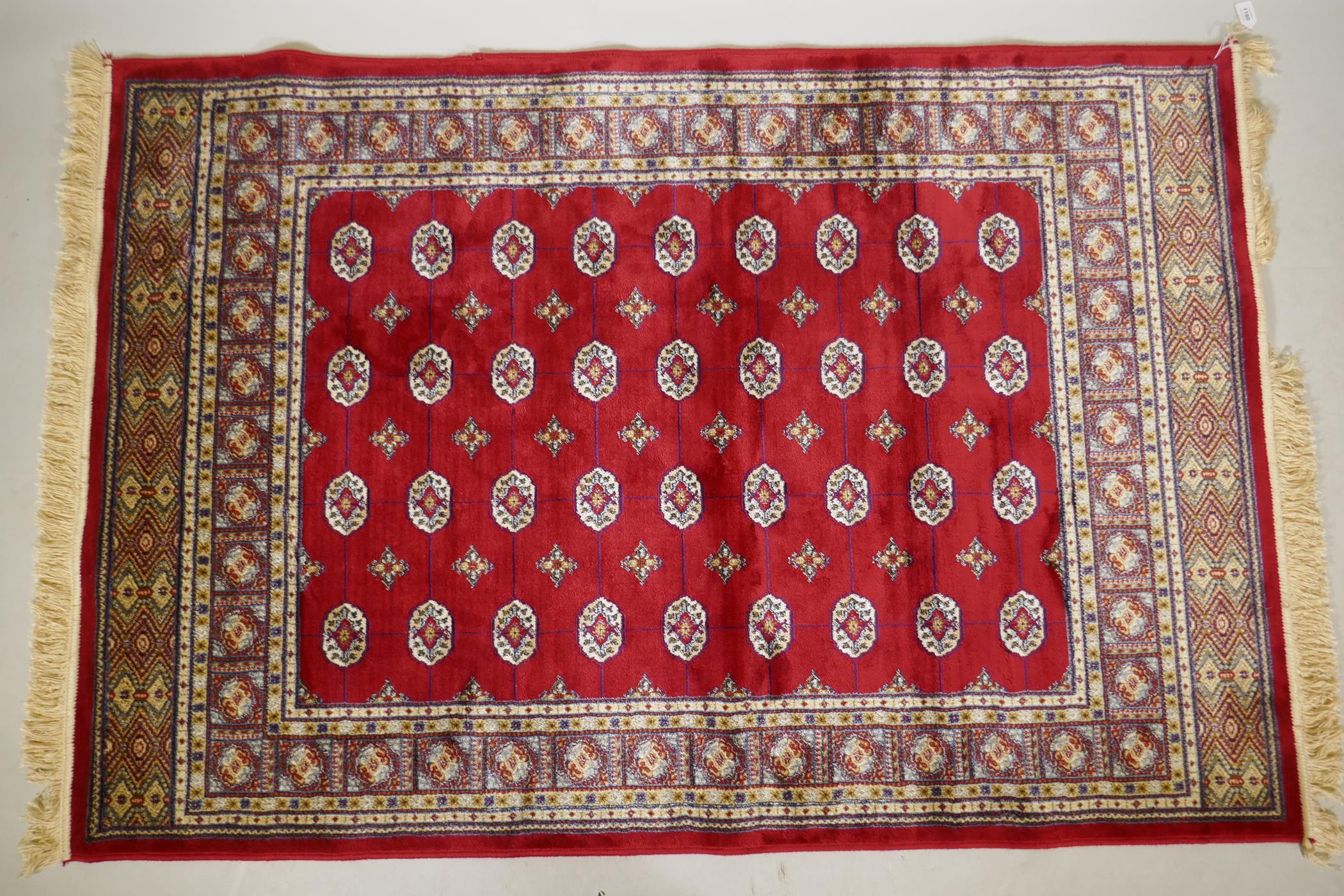 A rich red ground Kashmir rug with a Bokhara design, 47" x 69"