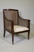 A C19th mahogany bergere armchair with ebony inlaid stringing, raise on square tapering supports