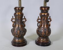 A pair of copper table lamps with oriental style decoration, 27" high with shade support