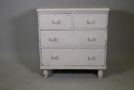 A C19th white painted pine chest of drawers, two short over two long, raised on turned supports,