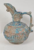 An Islamic earthenware jug, the body and spout with incised geometric patterns, 10" high